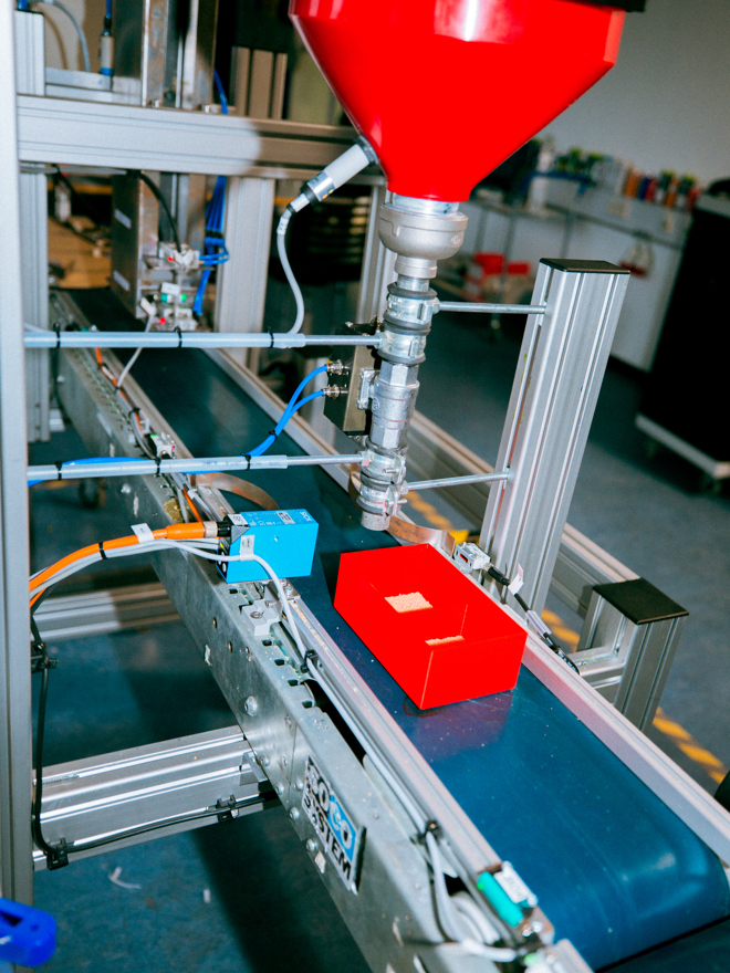 Rød æske på et transportbånd i en produktionslinje, transportbånd, produktion, automation, fabrik