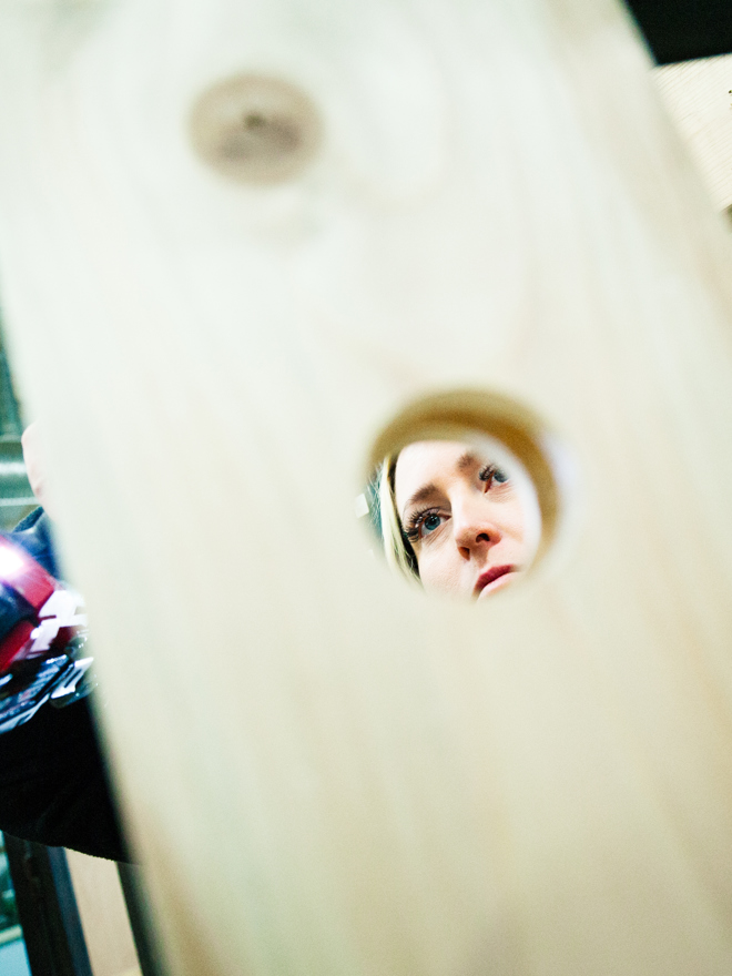 Person kigger gennem kighul i et træpanel i værkstedet, træpanel, værksted, håndværk, montage