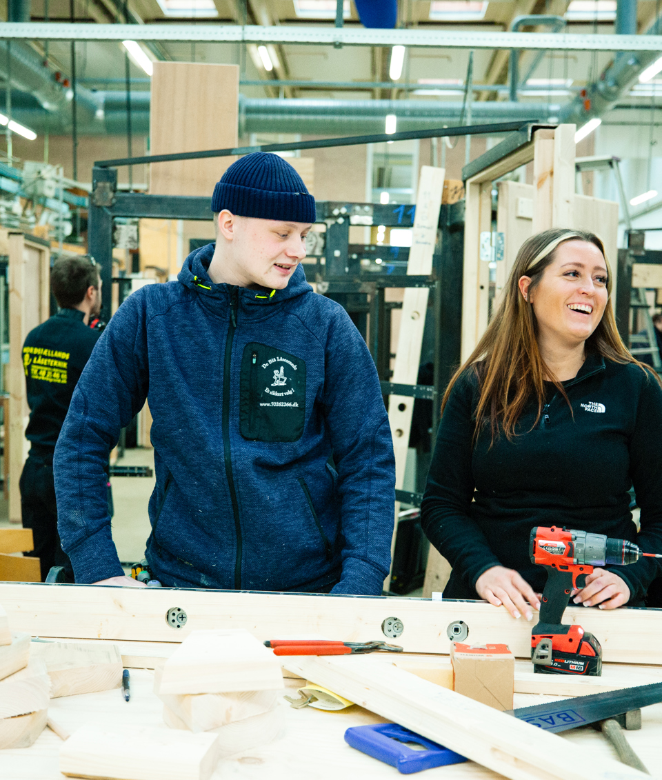 To personer arbejder ved en arbejdsbænk med værktøj og materialer, teamwork, arbejdsbænk, værktøj, materialer, værksted