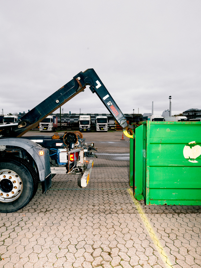 Lastbil løfter en container på en parkeringsplads under træning, containerløft, vejgodstransport, træning, parkeringsplads