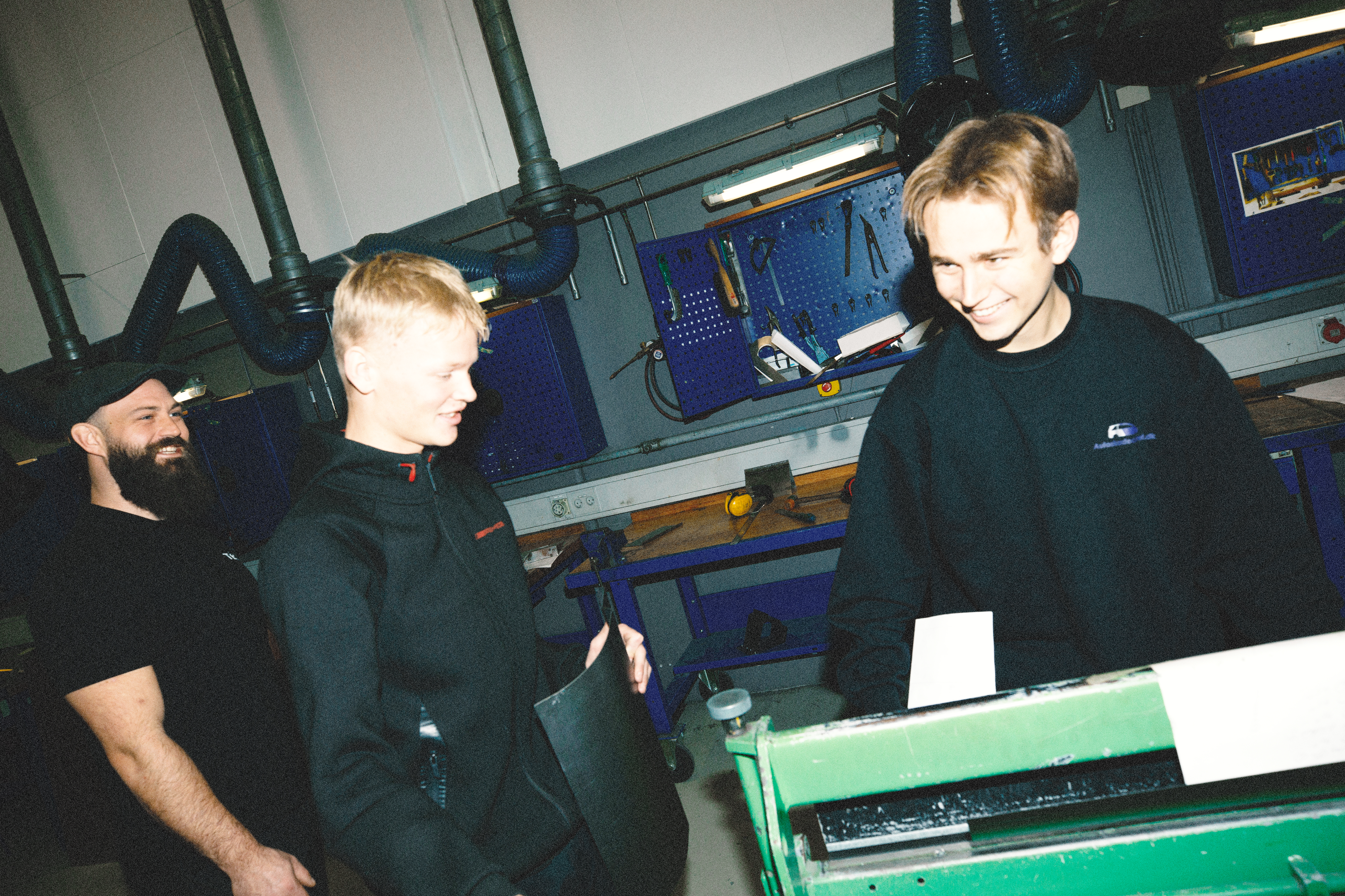 To arbejdere diskuterer arbejdet ved en maskine i værkstedet, diskussion, maskine, værksted, teamwork