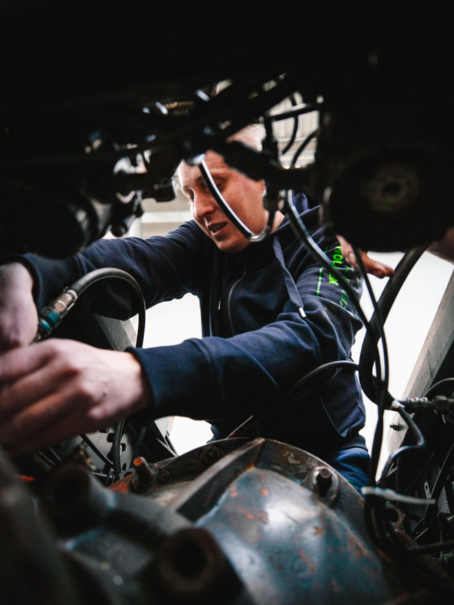 Mekaniker reparerer ledninger og komponenter i lastbilens motor, mekaniker, ledninger, komponenter, lastbilmotor