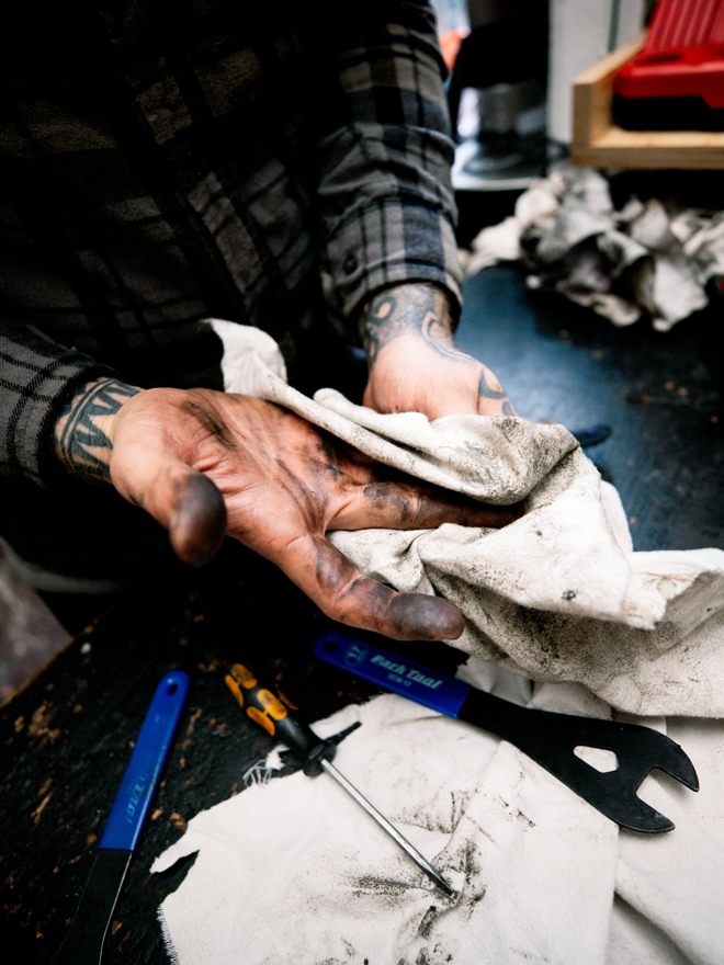 Mekaniker rengør cykeldele med klud og værktøj, cykelvedligeholdelse, rengøring, værktøj, cykelmekaniker