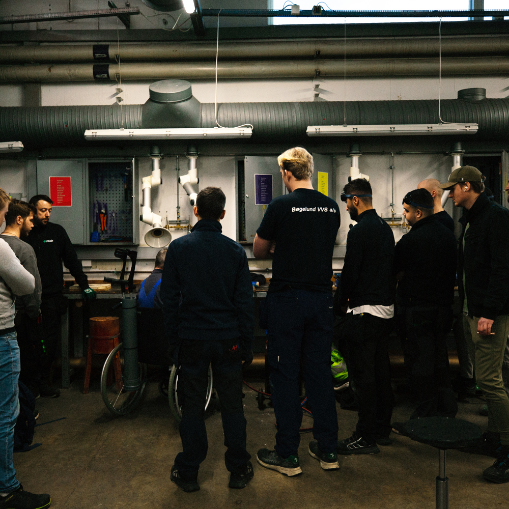 Gruppe af mennesker i et værksted, møde, VVS-team