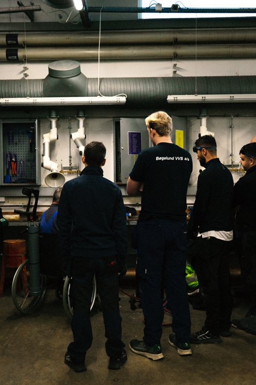 Gruppe af mennesker i et værksted, møde, VVS-team