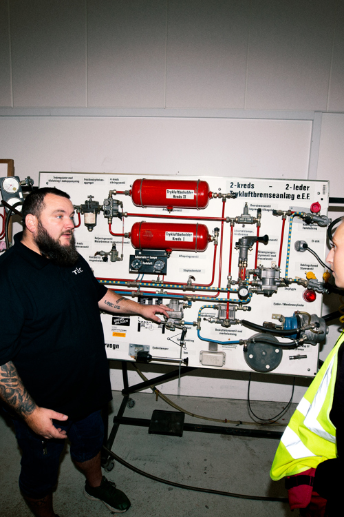 To personer snakker i et teknisk træningsmiljø med udstyr, teknisk træning, diskussion, vejgodstransport, udstyr, samarbejde