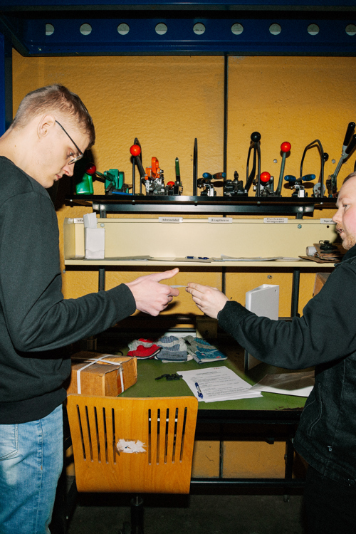 En lærling modtager instruktioner fra en kollega på lageret, lærling, instruktion, lagerarbejde, kollegaer, logistik, lager