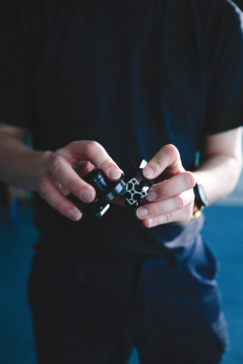 Elev holder en lille mekanisk komponent i hænderne, elev, mekanik, komponent, teknik, præcisionsarbejde