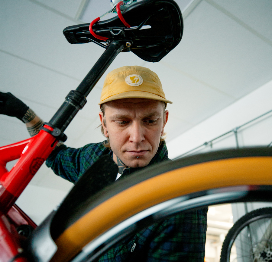  Mekaniker inspicerer en cykel i værkstedet, cykelreparation, cykelmekaniker, værksted, inspektion