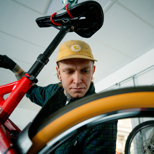 Mekaniker inspicerer en cykel i værkstedet, cykelreparation, cykelmekaniker, værksted, inspektion