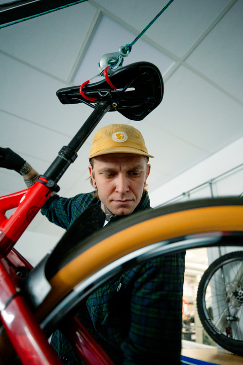 Mekaniker inspicerer en cykel i værkstedet, cykelreparation, cykelmekaniker, værksted, inspektion