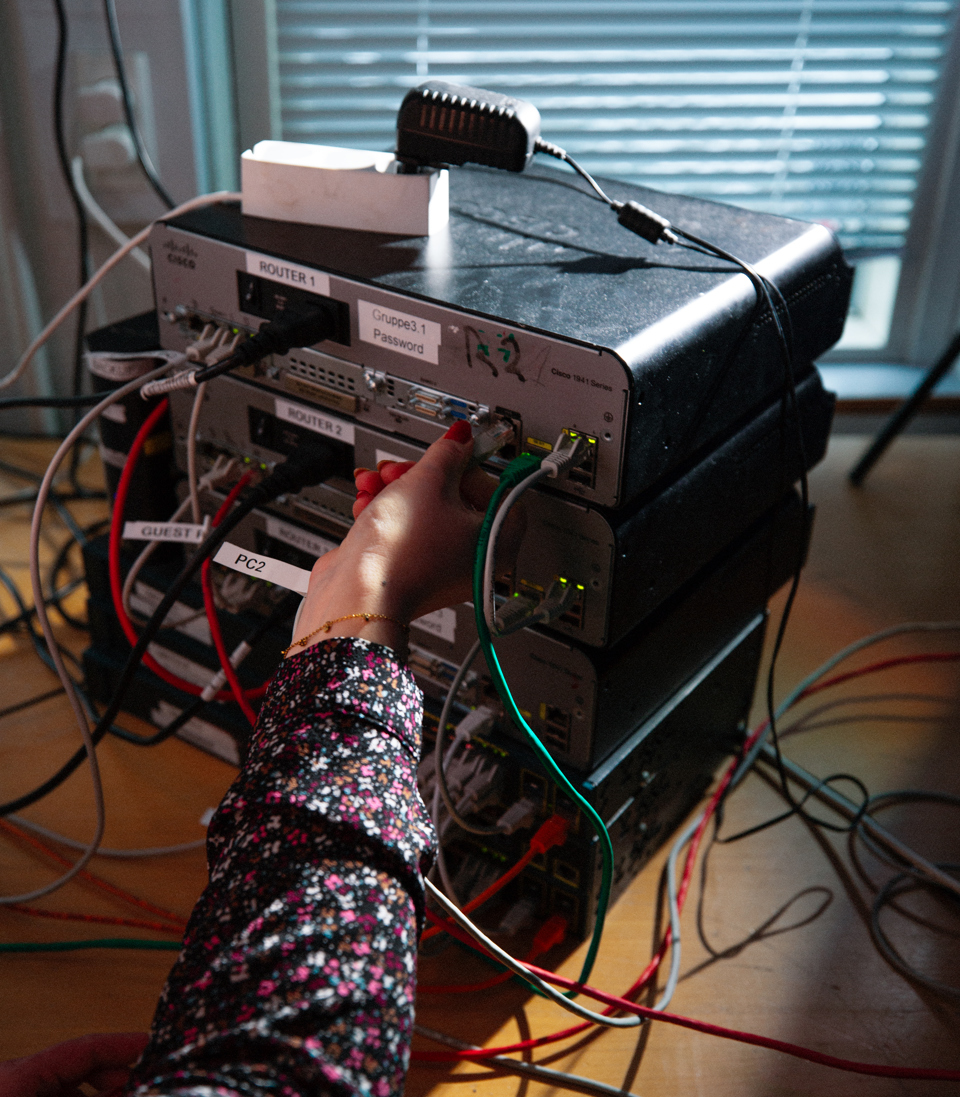 Person arbejder med netværksudstyr på data og kommunikation-uddannelsen, data og kommunikation, IT-uddannelse, netværksarbejde