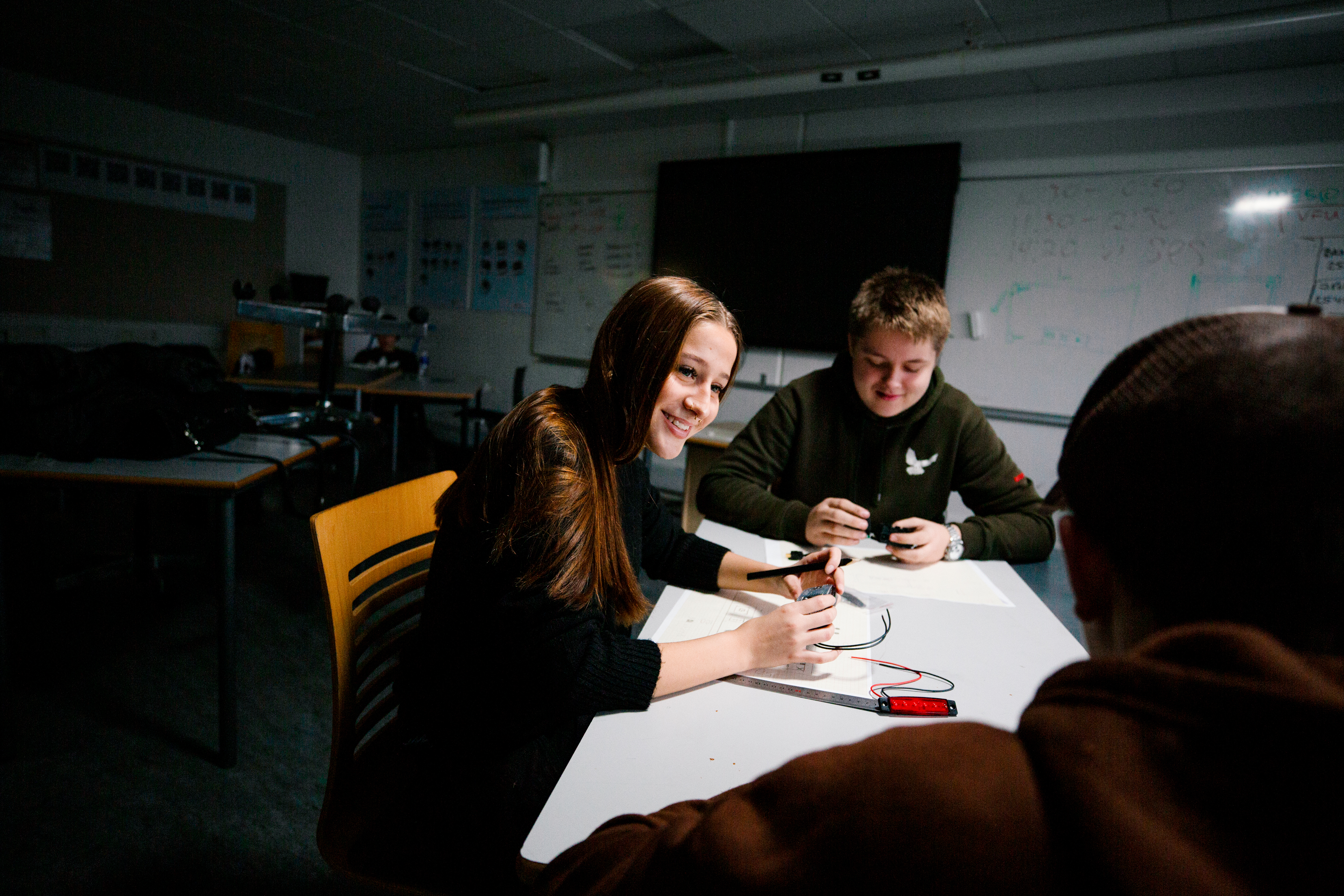 Gruppe GF 1 elever arbejder sammen om et projekt ved et bord i et klasseværelse, GF1, Gruppearbejde, Projektarbejde, Læringsmiljø, grundforløb, erhvervsuddannelse, erhvervsskole, uddannelse, elev