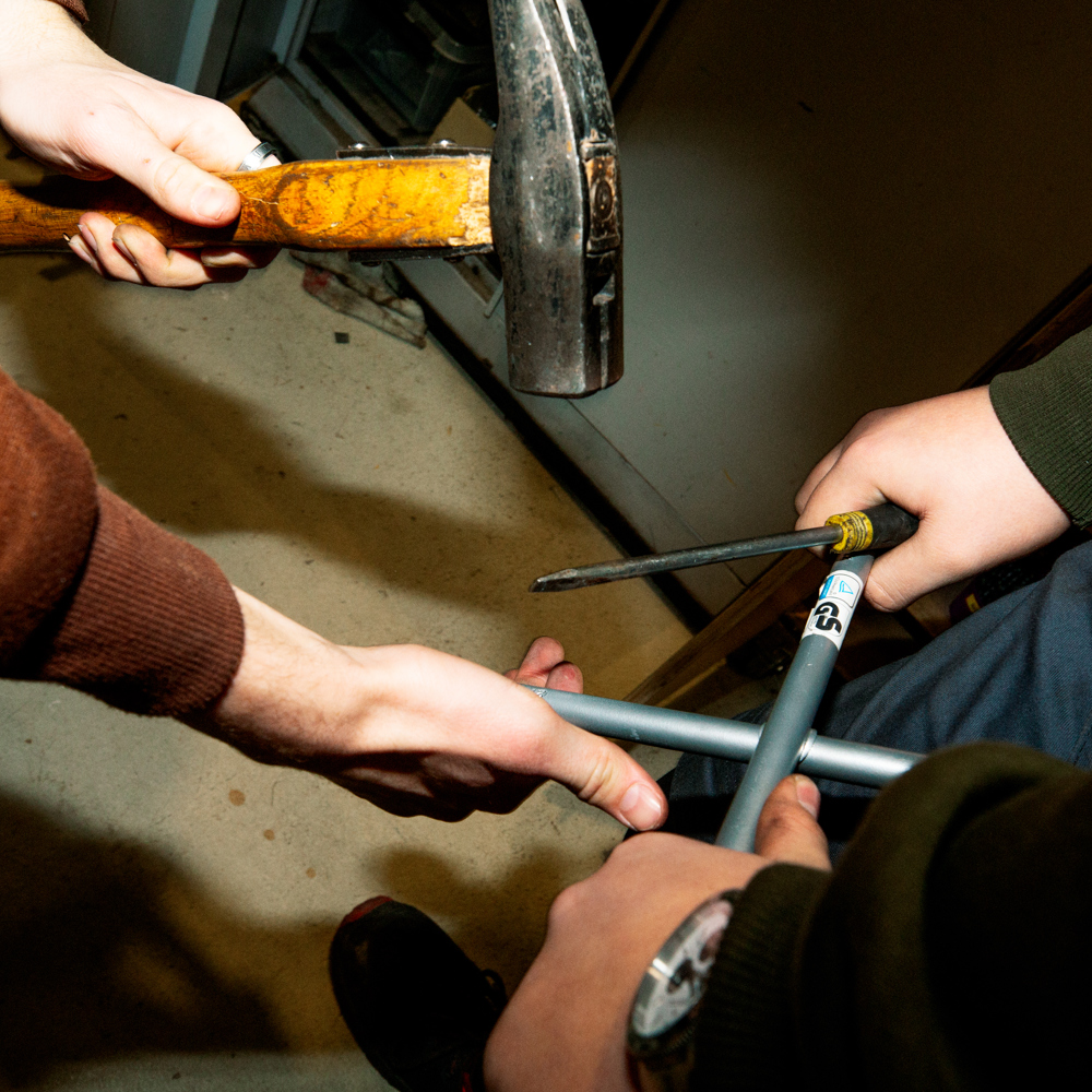 To elever arbejder sammen med rør og værktøj, inklusive en hammer, i et værkstedGF1, grundforløb, Samarbejde, Værksted,  Hammer, Værktøj,  Rørarbejde,  erhvervsuddannelse, erhvervsskole, uddannelse, elev