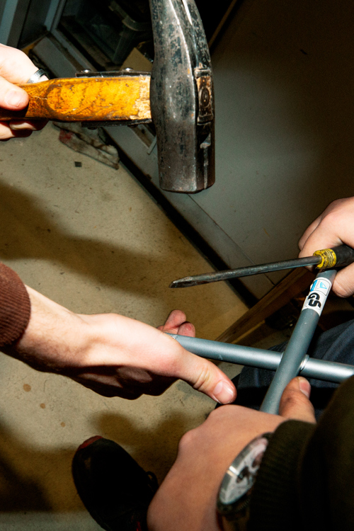 To elever arbejder sammen med rør og værktøj, inklusive en hammer, i et værkstedGF1, grundforløb, Samarbejde, Værksted,  Hammer, Værktøj,  Rørarbejde,  erhvervsuddannelse, erhvervsskole, uddannelse, elev