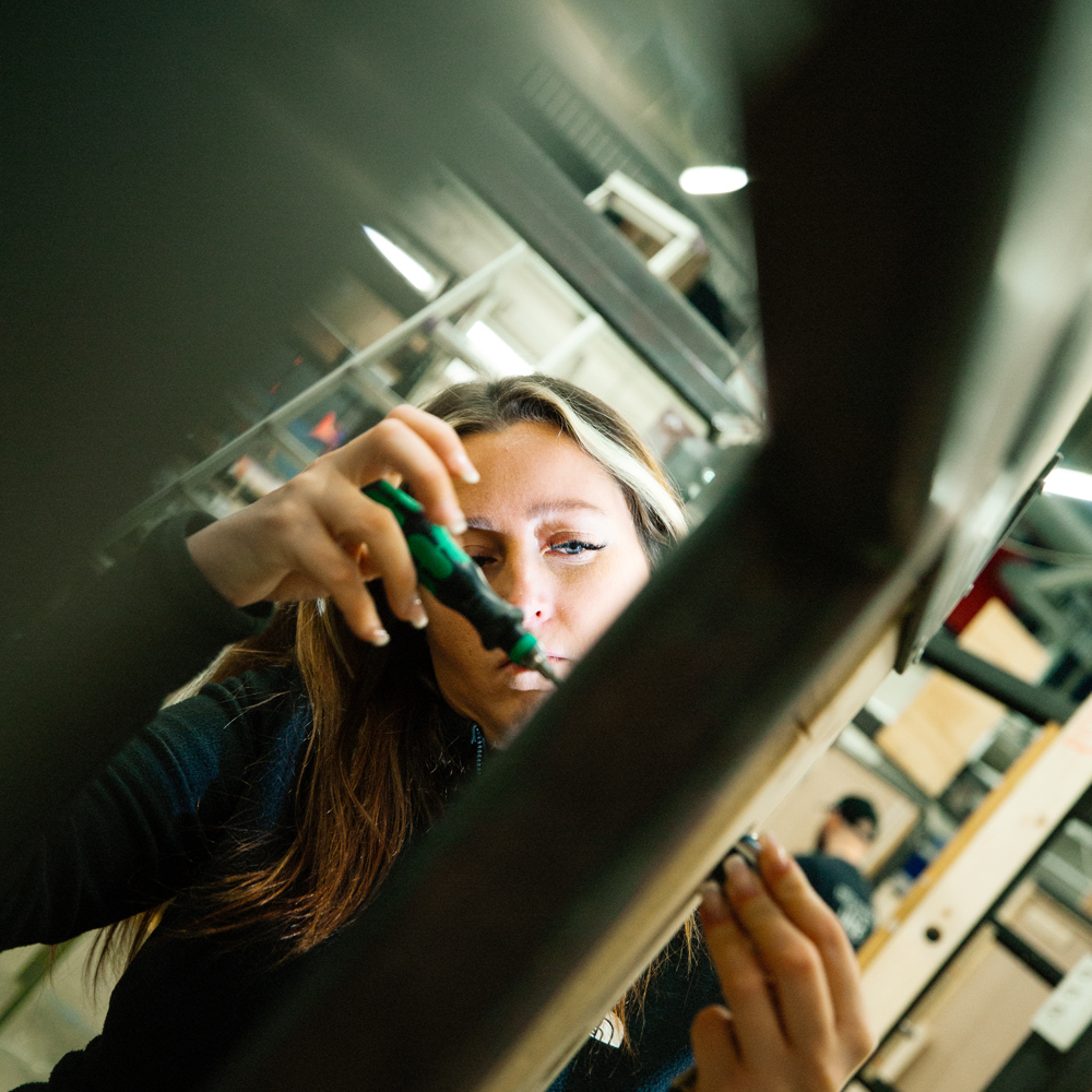 Kvinde arbejder med værktøj og måler i et værksted, værksted, værktøj, arbejde, måling