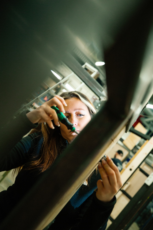 Kvinde arbejder med værktøj og måler i et værksted, værksted, værktøj, arbejde, måling