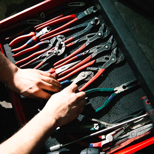 Hænder organiserer værktøj i en værktøjskasse i værkstedet, værktøjskasse, hænder, værktøj, værksted, organisering